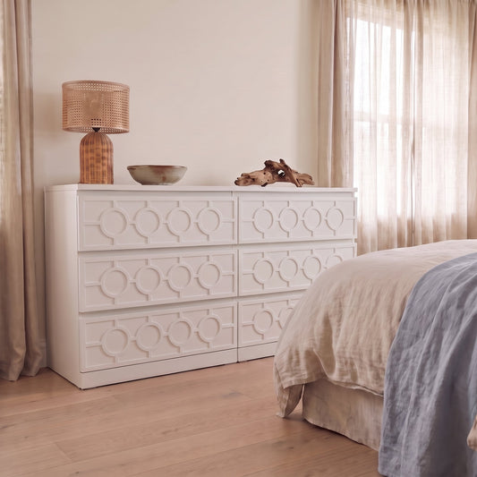 White nautical acrylic overlays covering the full drawer fronts of an IKEA Malm six drawer chest in a coastal bedroom