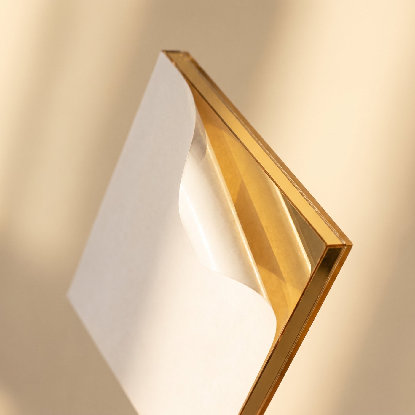Gold mirror overlay panel with peel-off adhesive backing being applied